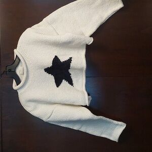 SUSS DESIGN white with black star knitted in front.